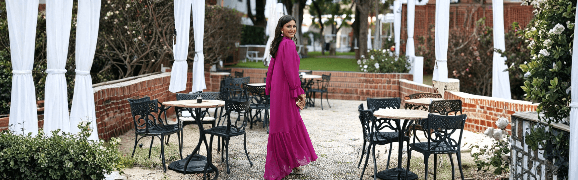 Mujer con vestido de fiesta de noche largo color púrpura en un ambiente al aire libre, lista para una celebración.