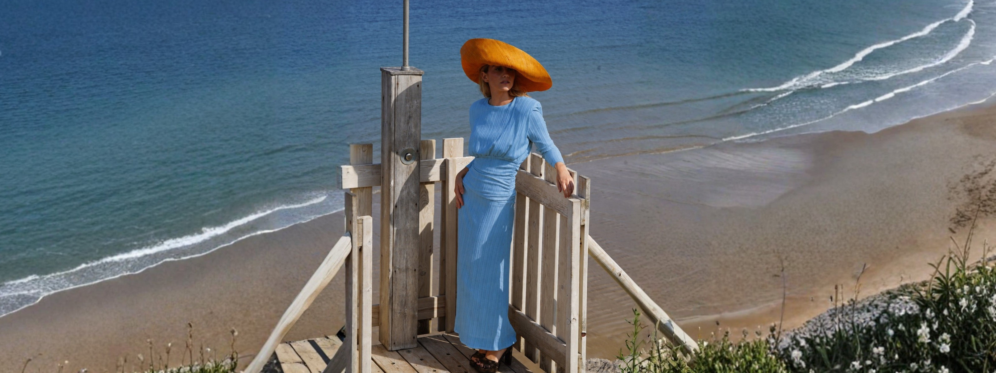 Modelo luciendo un vestido elegante en la entrada de una casa moderna, disfrutando de descuentos hasta el 50.