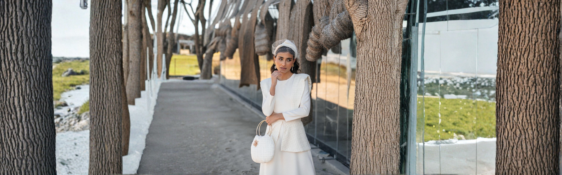 Modelo con tocado artesanal de invitada en un entorno natural, destacando su elegancia y estilo.