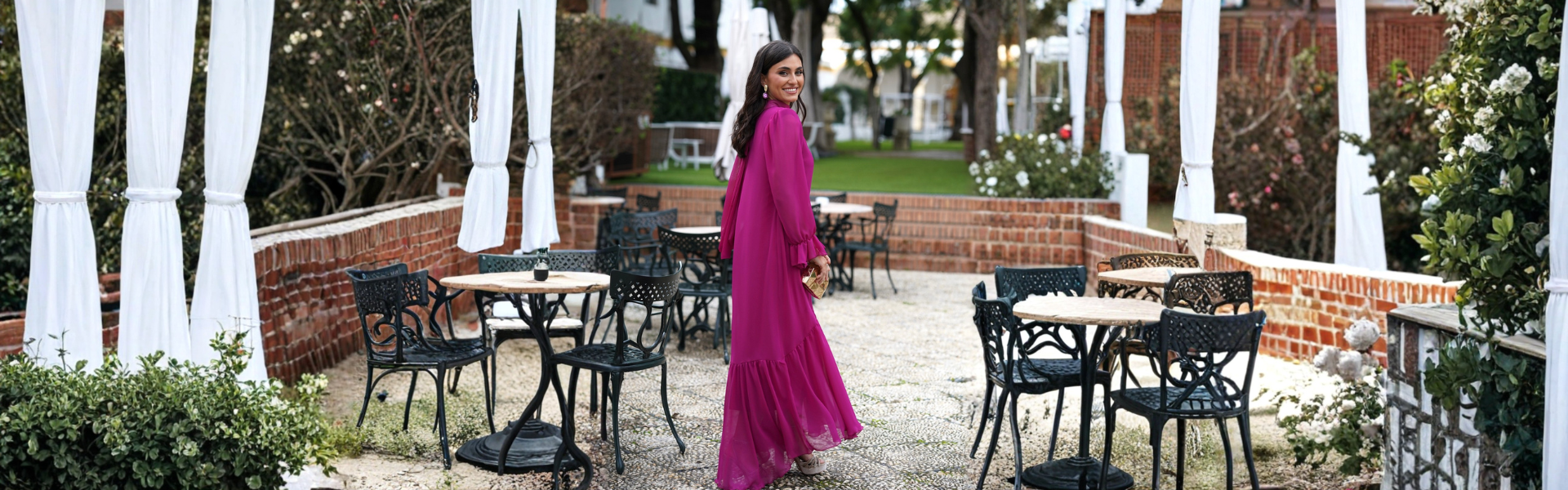 Mujer sonriente con vestido fucsia en un entorno de jardín, ideal para vestidos invitada boda invierno | Mariquita Trasquilá.