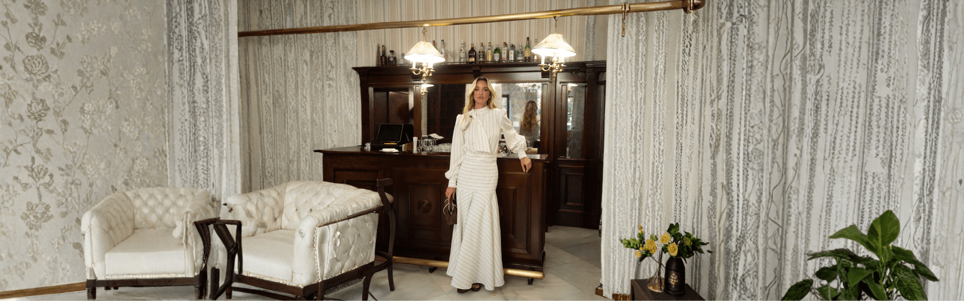 Vestidos de fiesta Mariquita Trasquilá en un elegante entorno interior con muebles clásicos y decoración sofisticada.