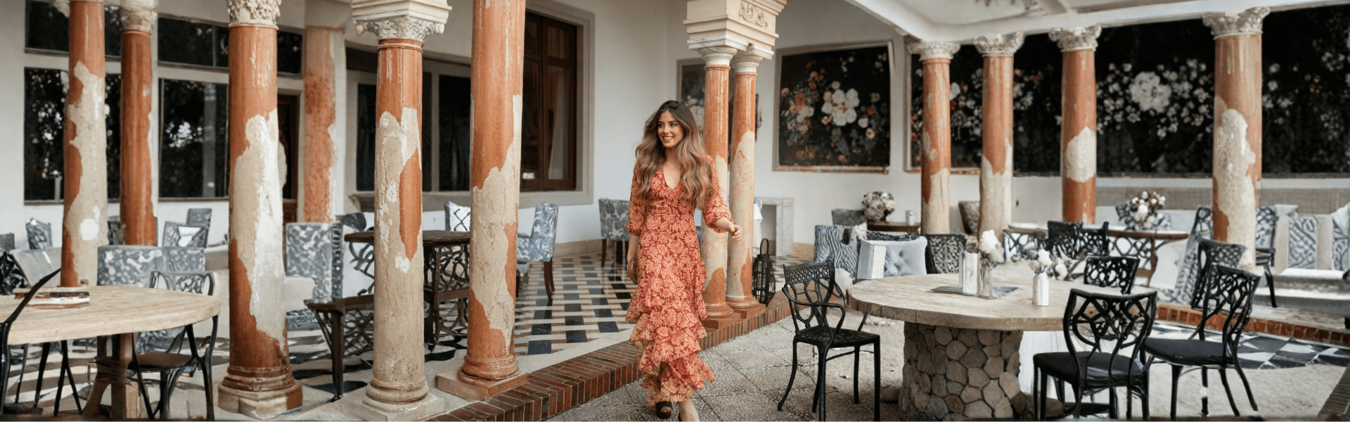 Modelo en un vestido corto de fiesta en un elegante salón con mesas y sillas, destacando como invitada ideal.