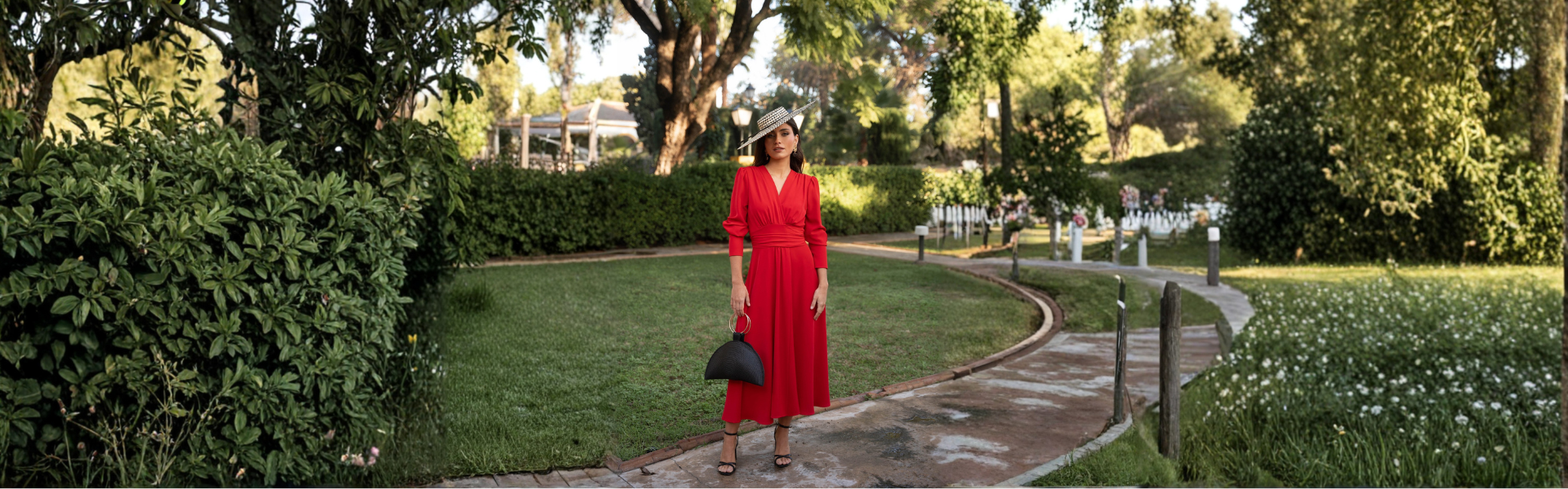 Mujer con vestido rojo invitada en un jardín, ideal para eventos y fiestas elegantes.