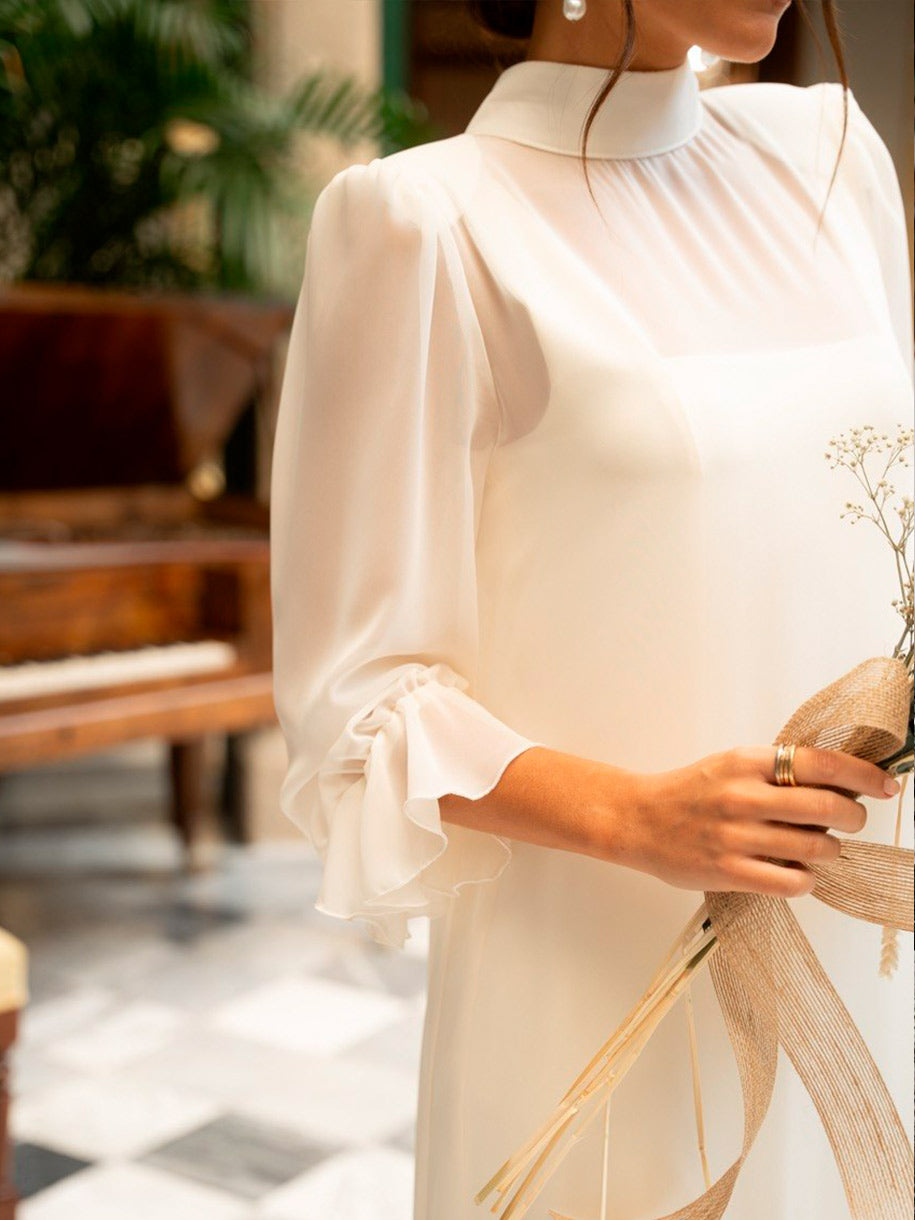 Vestido blanco con cuello subido y mangas fruncidas