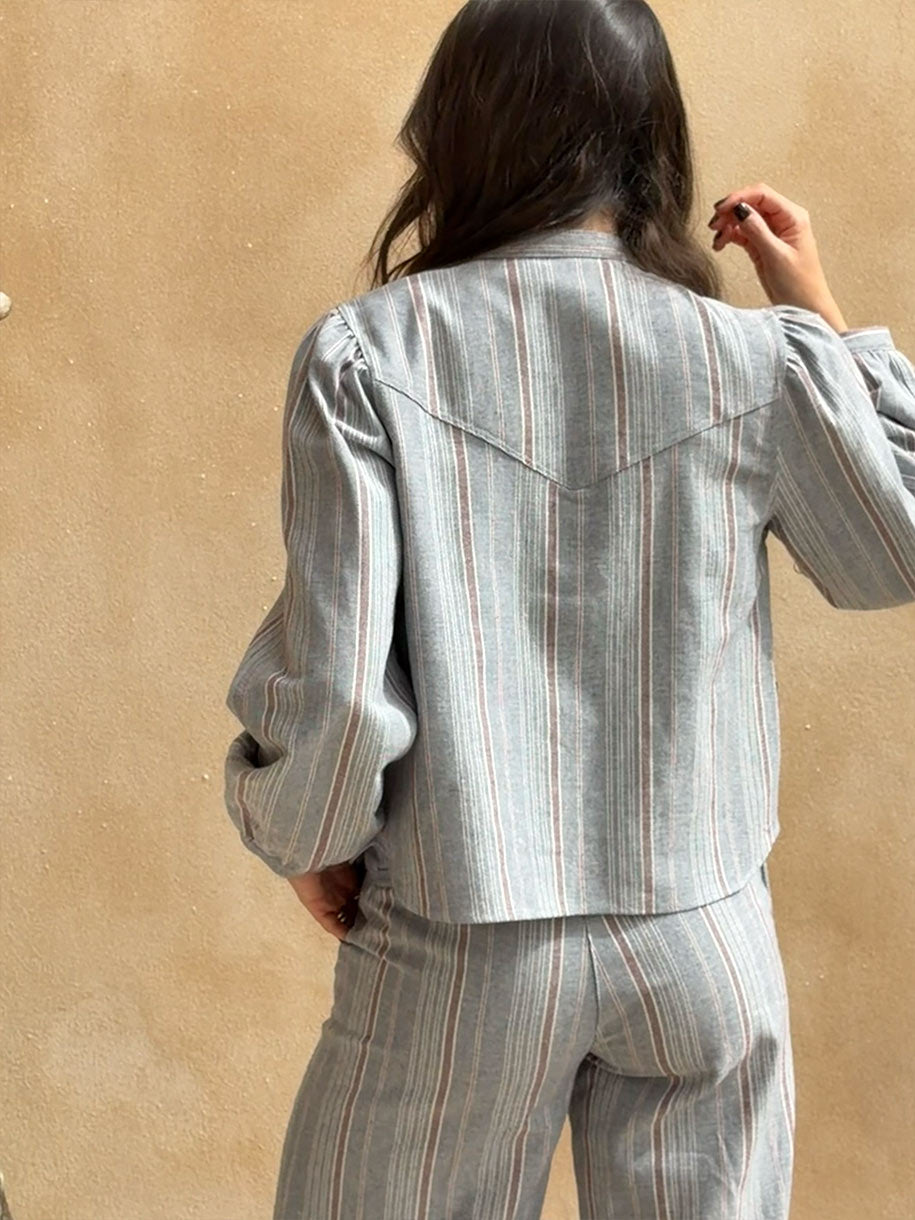 Chaqueta Rayas Denim de mujer, vista trasera con diseño de rayas y mangas abullonadas, estilo moderno y cómodo.